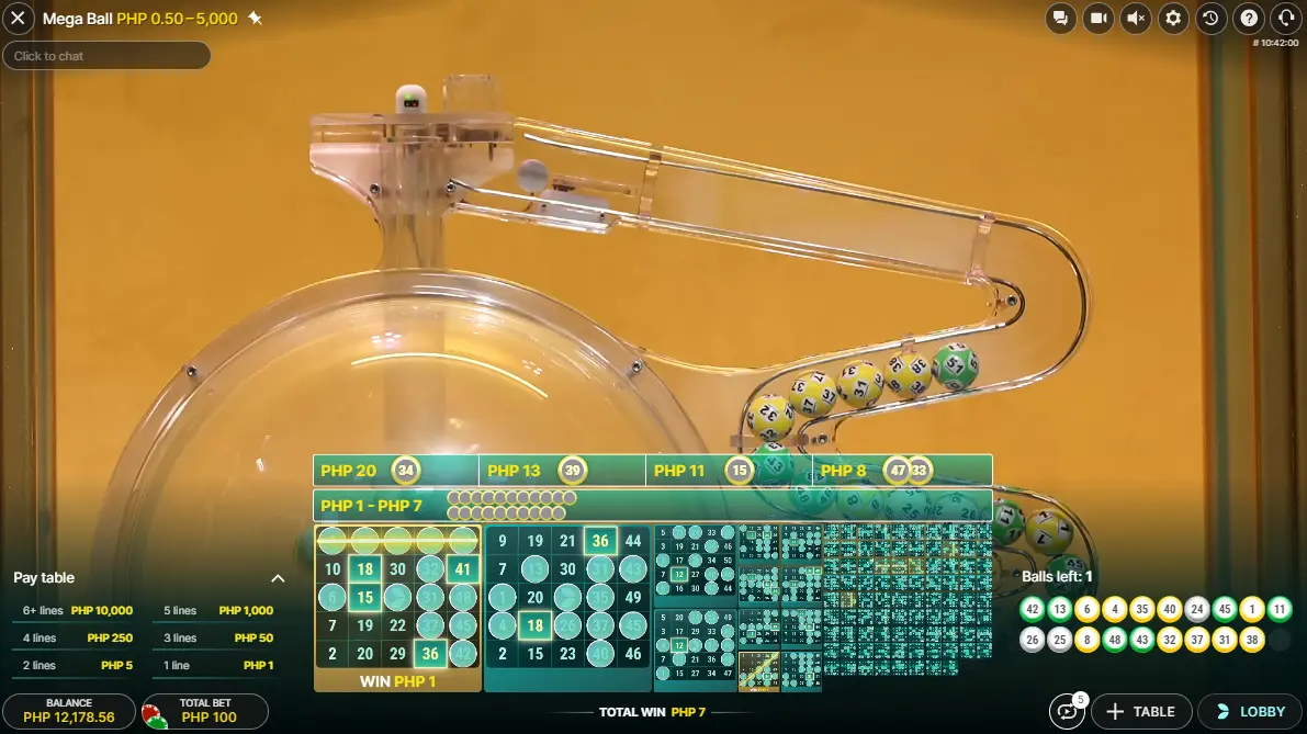 Screenshot of the Mega Ball game interface showing the live draw in progress with numbered balls being drawn into a clear tube against a yellow background. The player's balance, total bet, and a pay table are displayed alongside the winning numbers highlighted on bingo cards.